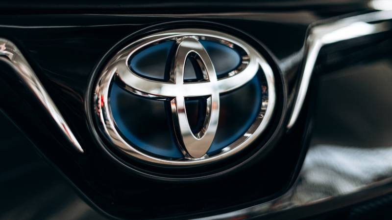 Blue logo of Toyota Hybrid car close-up. Toyota car in the showroom.